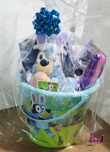 Gift basket with toys and a blue ribbon in a green bucket on a white background